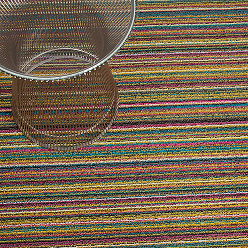 Skinny Stripe Shag Mat by Chilewich. Bright Multi 200134-002. UPC 0667880913525. Shag indoor/outdoor mats are made by tufting custom extruded yarns as loops onto a primary backing and then binding them onto a hardworking vinyl that could weather any storm outdoors and provides functionality underfoot indoors. 