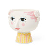 Bjørn Wiinblad represents everything that is crazy, quirky, creative and wonderful. And with the beautiful and smiling Eva flowerpot from Bjørn Wiinblad with pink hair and a bright pink and yellow dress, you can create a quirky, colourful vibe throughout your home. The flowerpot measures 14.5 cm in height and with a diameter of 15.5 cm, it is perfect for displaying herbs, trendy succulents, small plants or arranged flower compositions. 