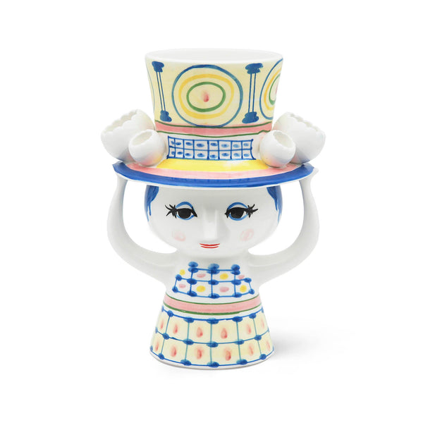 Bjorn Wiinblad Lady with Hat Vase H 8.1 in Blue. SKU 54050. UPC 5709513540502. Invite the new behatted lady inside to enjoy her sophisticated company. With her beautiful colours, quirky details and hand-painted decorations, the Lady with hat series is guaranteed to bring joy to your home. She can't shake your hand, however, because she's using both hands to balance the hat – and the flower, bouquet or candle you put inside it.
