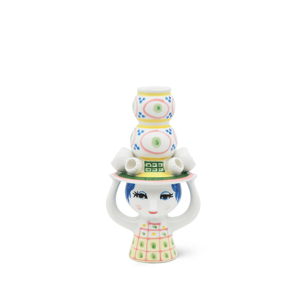Bjørn Wiinblad Lady Hat Candle Holder H 6.3 in pink. SKU 54052. UPC 5709513540526. The candleholder stands 16 cm tall and is predominantly pink with green, yellow and blue detailing. The hat grows like a small tower towards the sky, while the elegant lady balances it with her hands. 