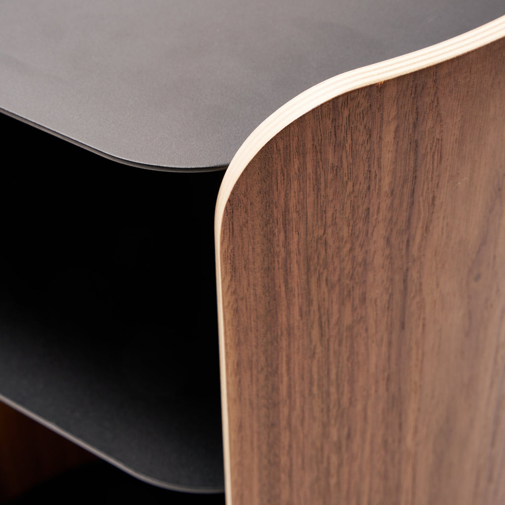 Apto Contour Side Table in walnut plywood and black powder-coated steel. SKU 10801. Bring style and function to any room with this modern three-tier steel and wood side table. Designed with your lifestyle in mind. The table features an opening in the back for easy cable management and charging. Balances modern steel surfaces with stylish molded plywood.