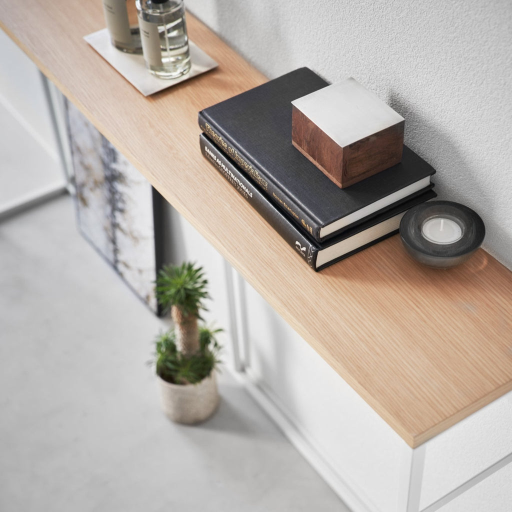 With a natural woodgrain top and minimalistic steel legs, this sleek design magically makes everything placed upon it look intentionally styled. 