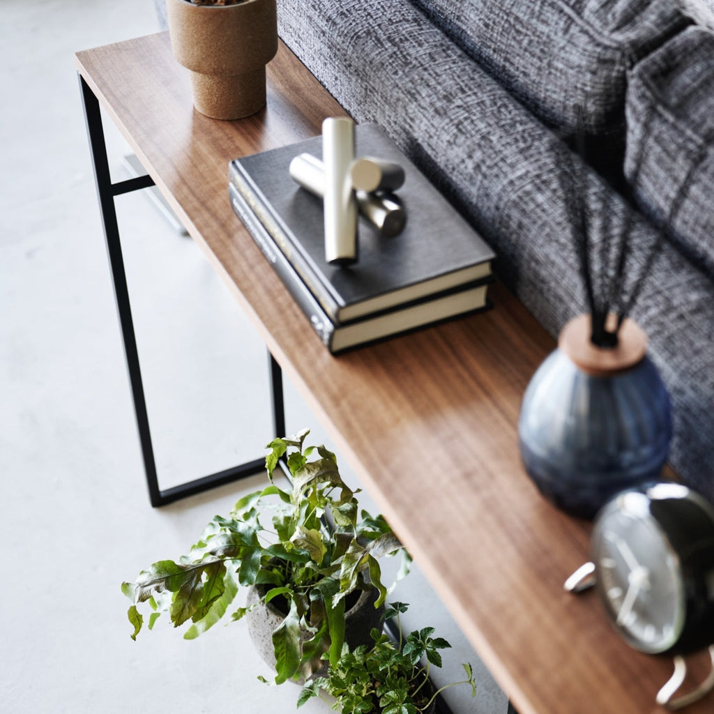 With a natural woodgrain top and minimalistic steel legs, this sleek design magically makes everything placed upon it look intentionally styled.