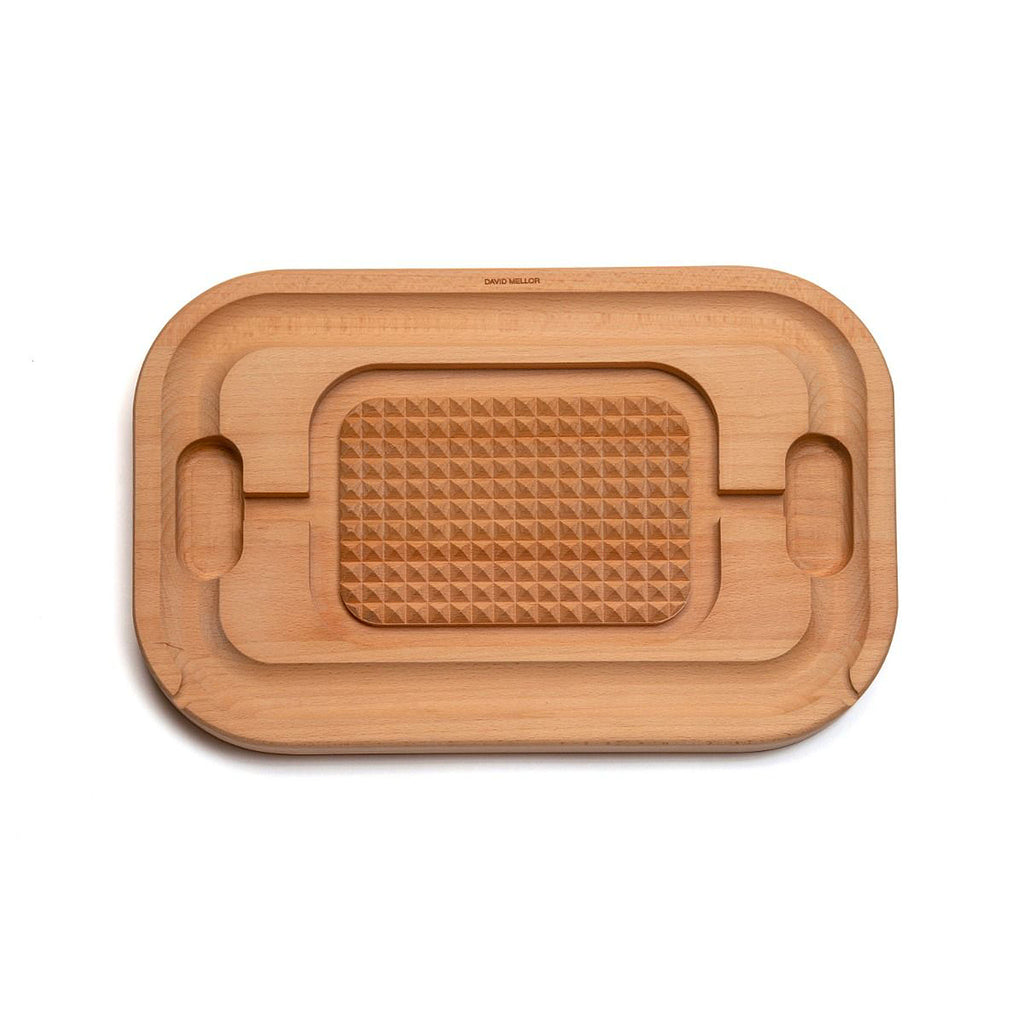 David Mellor Design Carving board 45cm. SKU 2450206. Our own-brand cutting boards are handmade in wood from sustainable sources by small specialist craft workshops. These are really top quality products. The natural finish and smooth surface of the specially selected hardwoods make them ideal for kitchen use. Oiled European beech with a ridged centre for anchoring joint while cutting and an excellent groove for collecting juices.