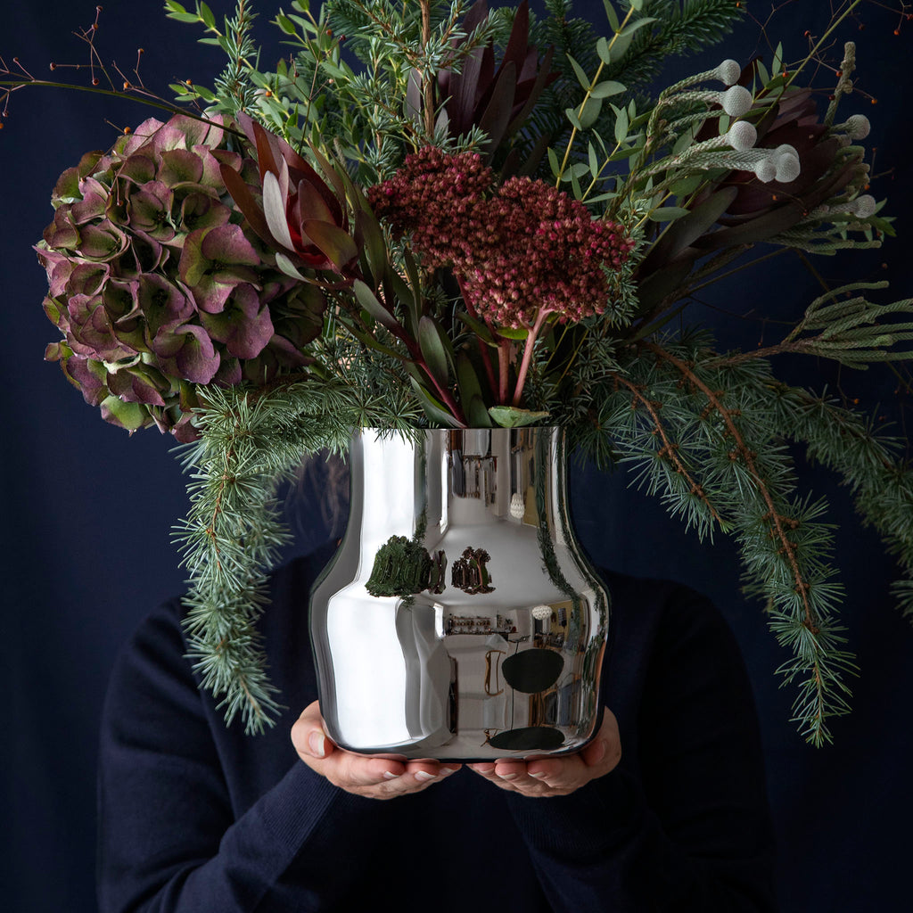 Dorotea Polished Steel Vase L. SKU FHGEN-30084. Crafted from recycled 18/10 polished stainless steel, the vase’s sleek surface and reflective finish bring a modern elegance to any space, capturing the light and adding a striking, yet serene, accent to your decor.
