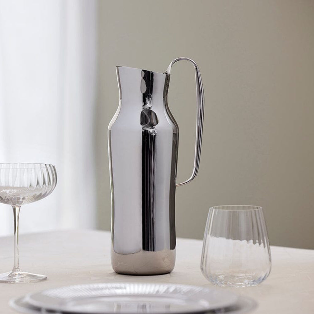This carafe, made of polished 18/10 stainless steel, is inspired by the natural area around the small village of Dorotea. Here, ice has created a landscape of mountains, valleys and large open areas which together form soft, fluid shapes that endlessly flow together. This transition is often overlooked, but the adventurous and surprising part of the design lies precisely here. With its minimalist and organic shapes, the Dorotea collection combines tradition and artisanal design on an international level.
