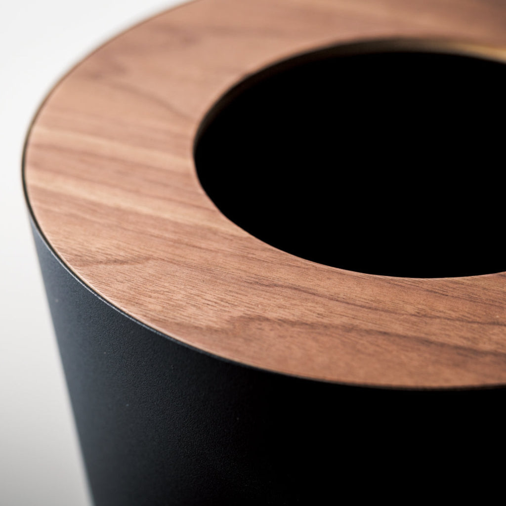 Comes in round and rectangular versions. Rin features wood components, made of ash or walnut. Some variation in wood grain and color is expected. With the wooden lid attached, the rectangular Rin has an opening that measures 8 x 2.875 inches. The opening of the wooden lid in the round Rin has a diameter of 5 inches.