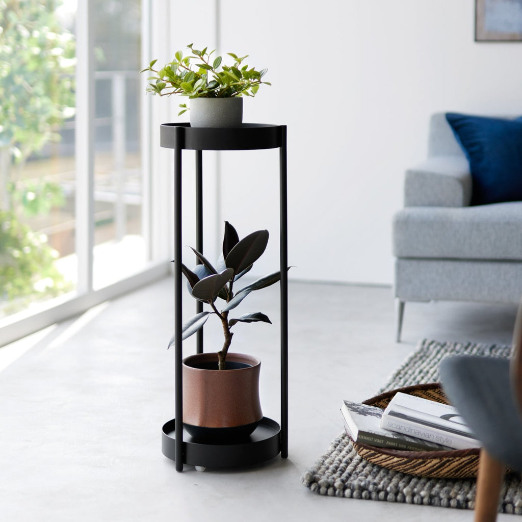 This two-tier plant stand can accommodate up to two potted plants: place a larger plants on the bottom and smaller plants on the top tier. The vertical design allows for a stylish and compact way to display your indoor greenery. Plus, the three-pillar design creates adequate spacing between poles so you can easily switch out plants as you please.