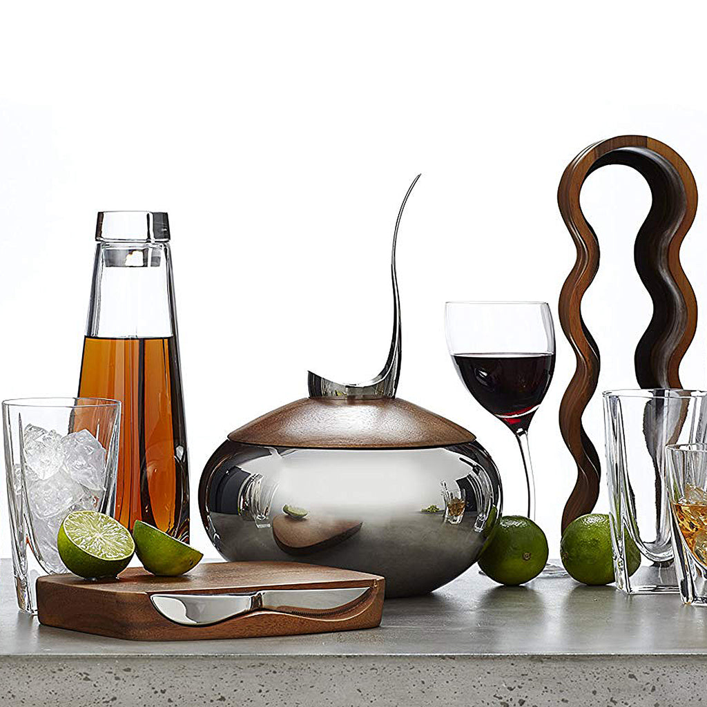 Resting on its Nambé Alloy base, the Curvo Wine Rack’s acacia wood form curves rhythmically to create spaces for four wine bottles. A beautiful and functional art piece, it can be displayed from the side or the front for two distinct effects.