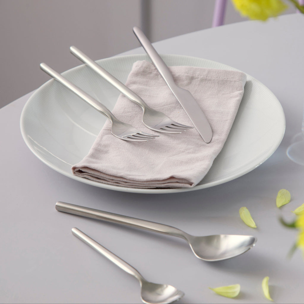 Dorotea 5-Piece Cutlery Set. The design is inspired by the nature around the small village of Dorotea. Here the ice the ice has created a landscape of mountains, valleys and large open spaces that together form soft, flowing shapes that endlessly replace each other. This transition is often overlooked, yet this is where the adventurous and surprising part of the design lies. 