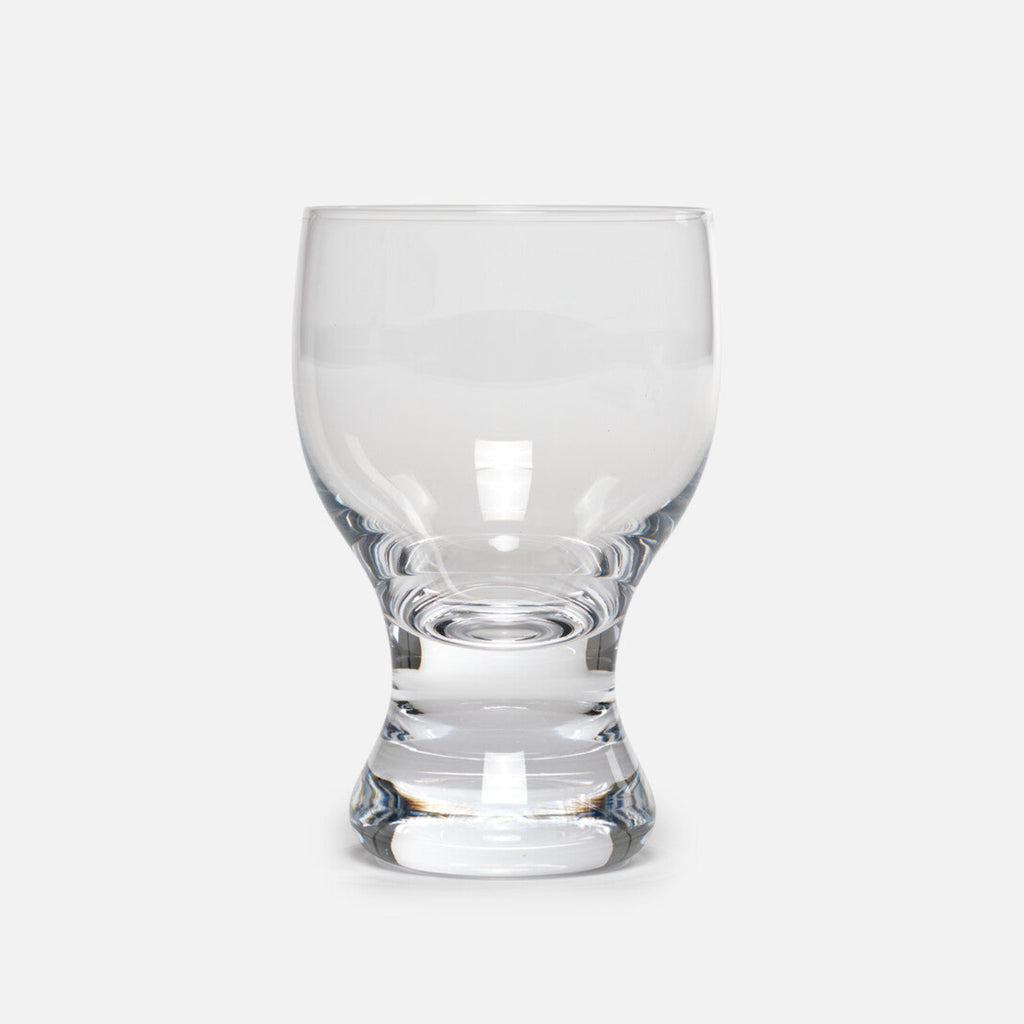 A hand-blown reissue of the 1979 design by famous industrial designer Sori Yanagi. The thick stem allows your hands to wrap comfortably around, and the heavy base sits securely on a table. The rim is slightly thicker than a traditional wine glass and the gentle curves create a flow that invites touch. More than just a wine glass, this sturdy vessel accommodates anything from a beer to a Coke float topped with ice cream. Available in both small and large sizes.