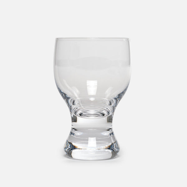 A hand-blown reissue of the 1979 design by famous industrial designer Sori Yanagi. The thick stem allows your hands to wrap comfortably around, and the heavy base sits securely on a table. The rim is slightly thicker than a traditional wine glass and the gentle curves create a flow that invites touch. More than just a wine glass, this sturdy vessel accommodates anything from a beer to a Coke float topped with ice cream. Available in both small and large sizes.
