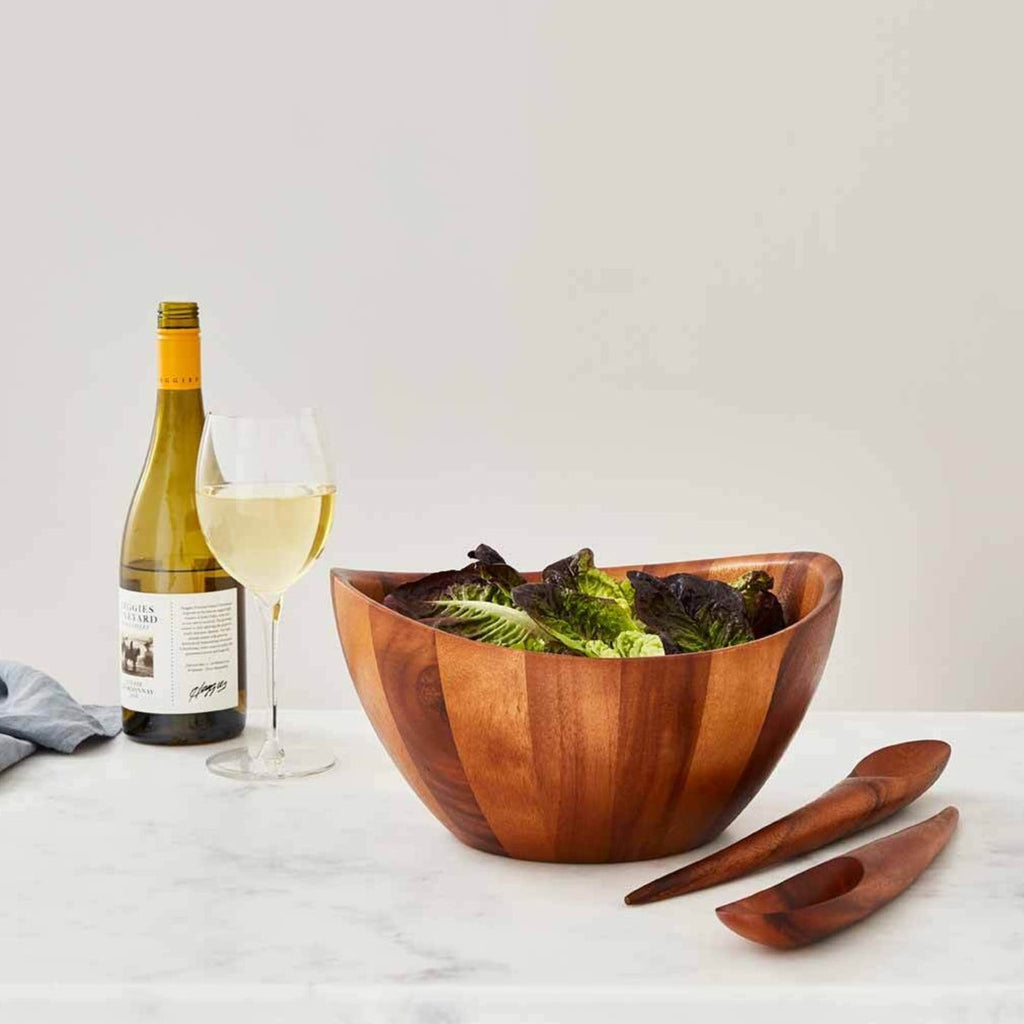 Elegant lines and flowing curves done in rich, gorgeous acacia wood make the Harmony Salad Set an instant classic. The generously rounded bowl paired with the unique shape of the tongs make it easy to toss and arrange your healthy creations. SKU: MT0582.