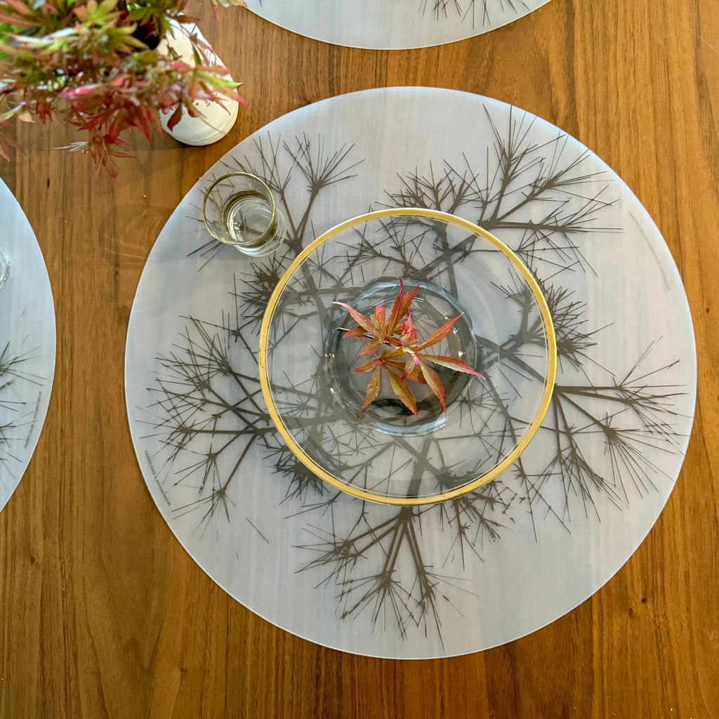 Round Placemat : Asawa Nest by Modern-Twist. Bring botanical beauty to your table with this soft, beautifully translucent pattern that enhances any surface while keeping lead, latex, phthalates, BPAs, & other harsh chemicals far away from your dinner. This forgiving placemat protects your surfaces from heat & water damage with silky soft, memory-free silicone that never wears or tears. UPC# 854796002362.