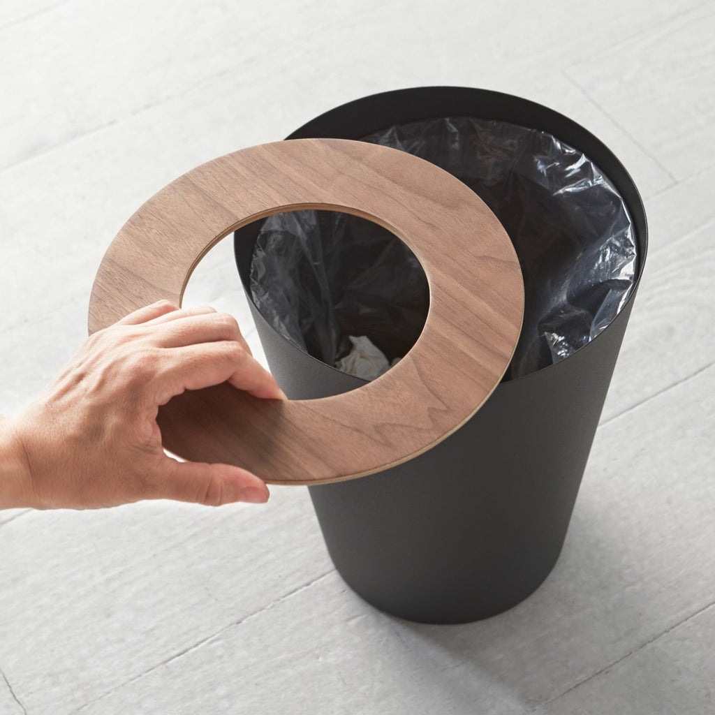 Comes in round and rectangular versions. Rin features wood components, made of ash or walnut. Some variation in wood grain and color is expected. With the wooden lid attached, the rectangular Rin has an opening that measures 8 x 2.875 inches. The opening of the wooden lid in the round Rin has a diameter of 5 inches.