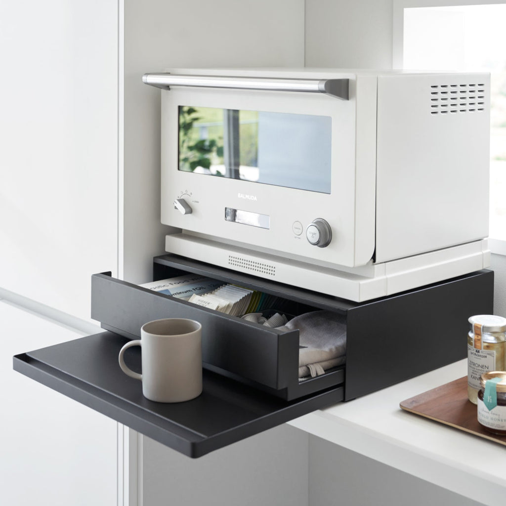A kitchen drawer, pull-out shelf, and appliance stand in one, this organizer creates space and convenience in the kitchen.