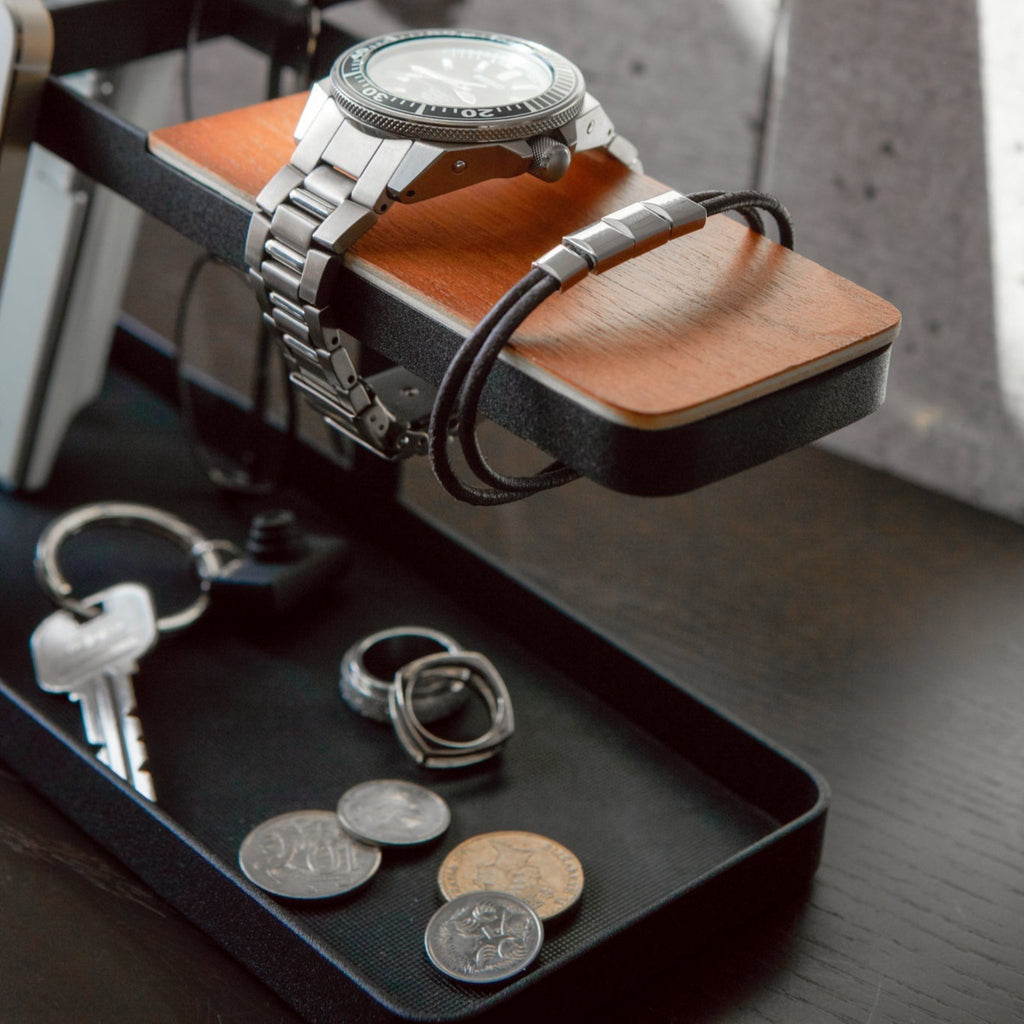 Two compartments keep items separated. A silicone mat rests at the bottom to keep items from sliding around. The extended arm (the section covered in wood) can be used for bracelets or up to two large watches. 