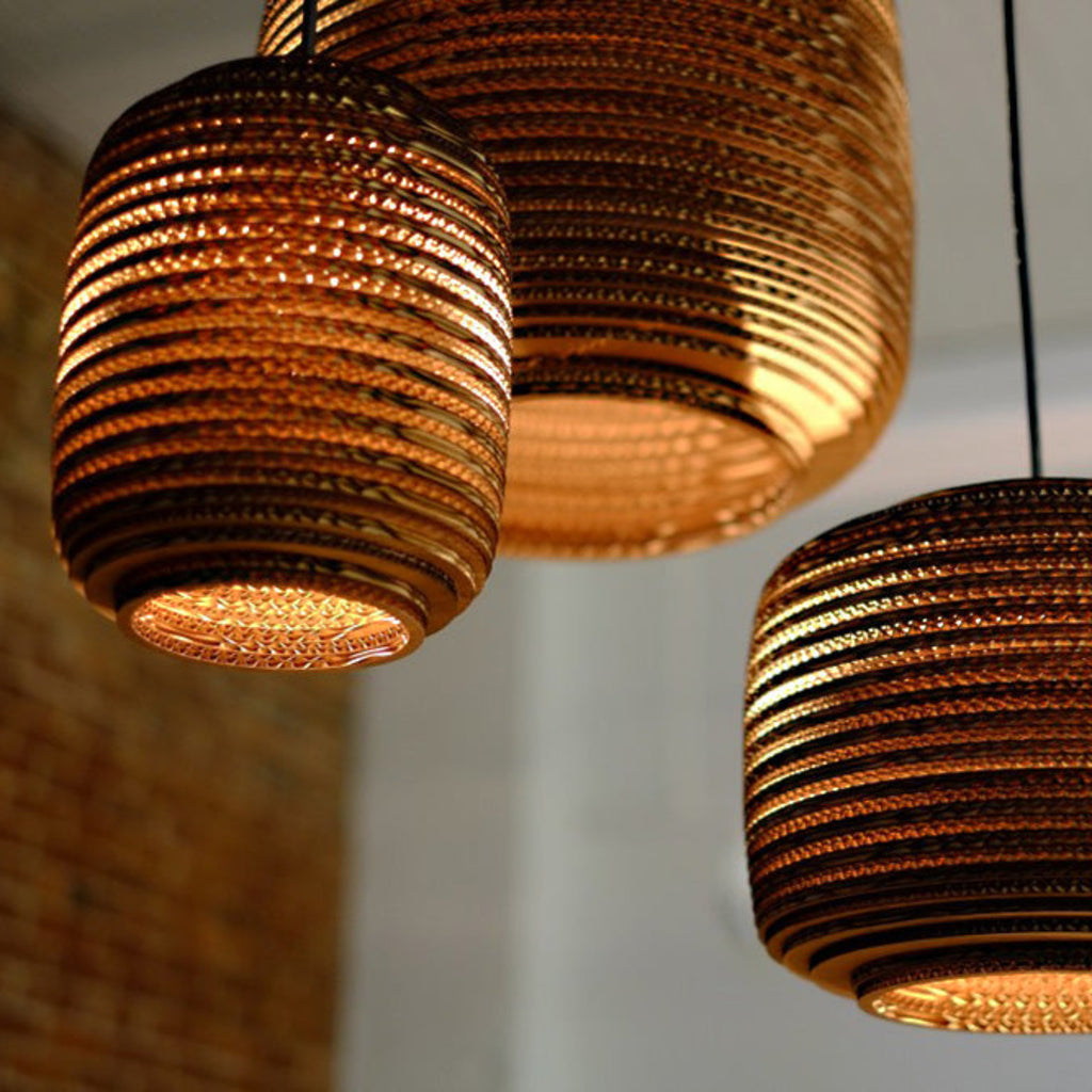 Scraplights are constructed from natural recycled cardboard precision cut by a laser. This gives the edges their classic dark appearance and enhances the warm light projected through the corrugation. Ausi is available in three colors and 3 sizes.
