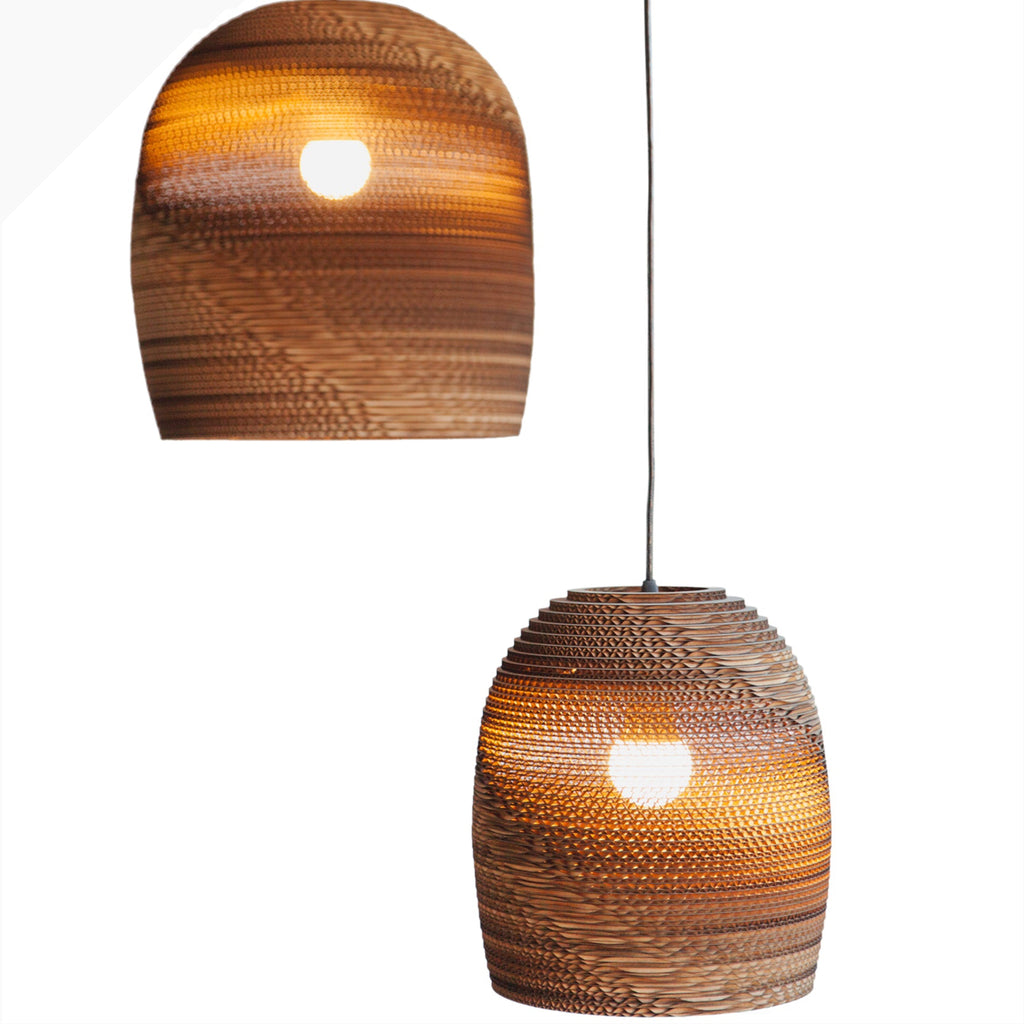 Handcrafted from 100% post-consumer recycled cardboard, our flagship Scraplights provide warm, intimate, and functional lighting for any occasion or space. Tough and elegant, each pendant is precision cut with a laser, giving the edges a slightly dark appearance and enhancing the warm light projected through the corrugation. Scraplights are assembled by hand using non-toxic adhesive and treated with a non-toxic fire retardant.