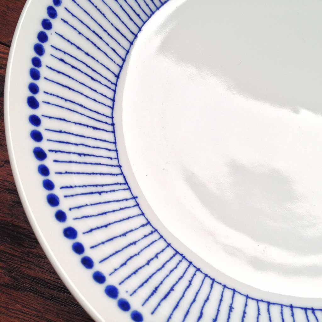 Sou Tokusa Blue and White Dinnerware Collection. These Japanese ceramic bowls feature a pattern of small blue dots along the rim with blue vertical strokes reminiscent of thin, straight tokusa plants. Made in Japan.