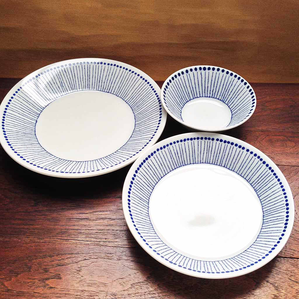 Sou Tokusa Blue and White Dinnerware Collection. These Japanese ceramic bowls feature a pattern of small blue dots along the rim with blue vertical strokes reminiscent of thin, straight tokusa plants. Made in Japan.