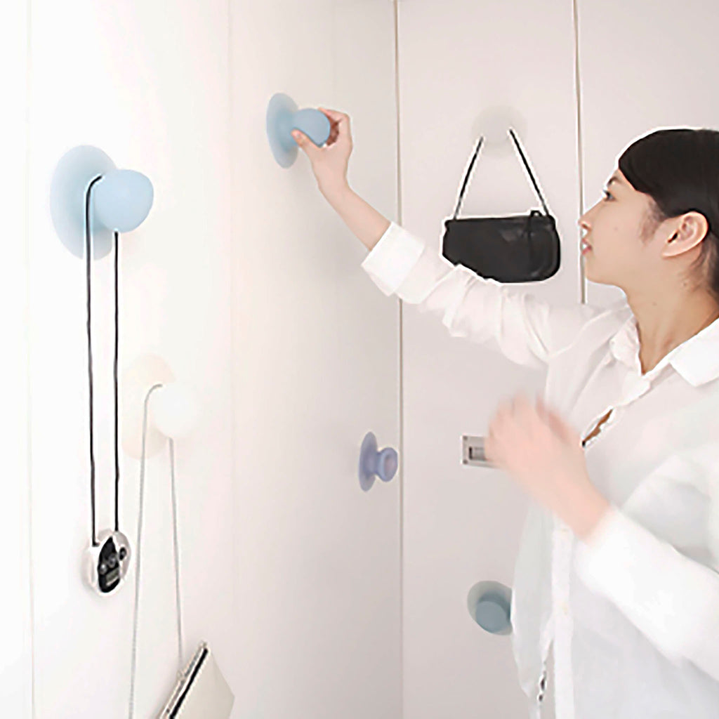 Using a blue Droog Sucker as a hook on a white wardrobe.