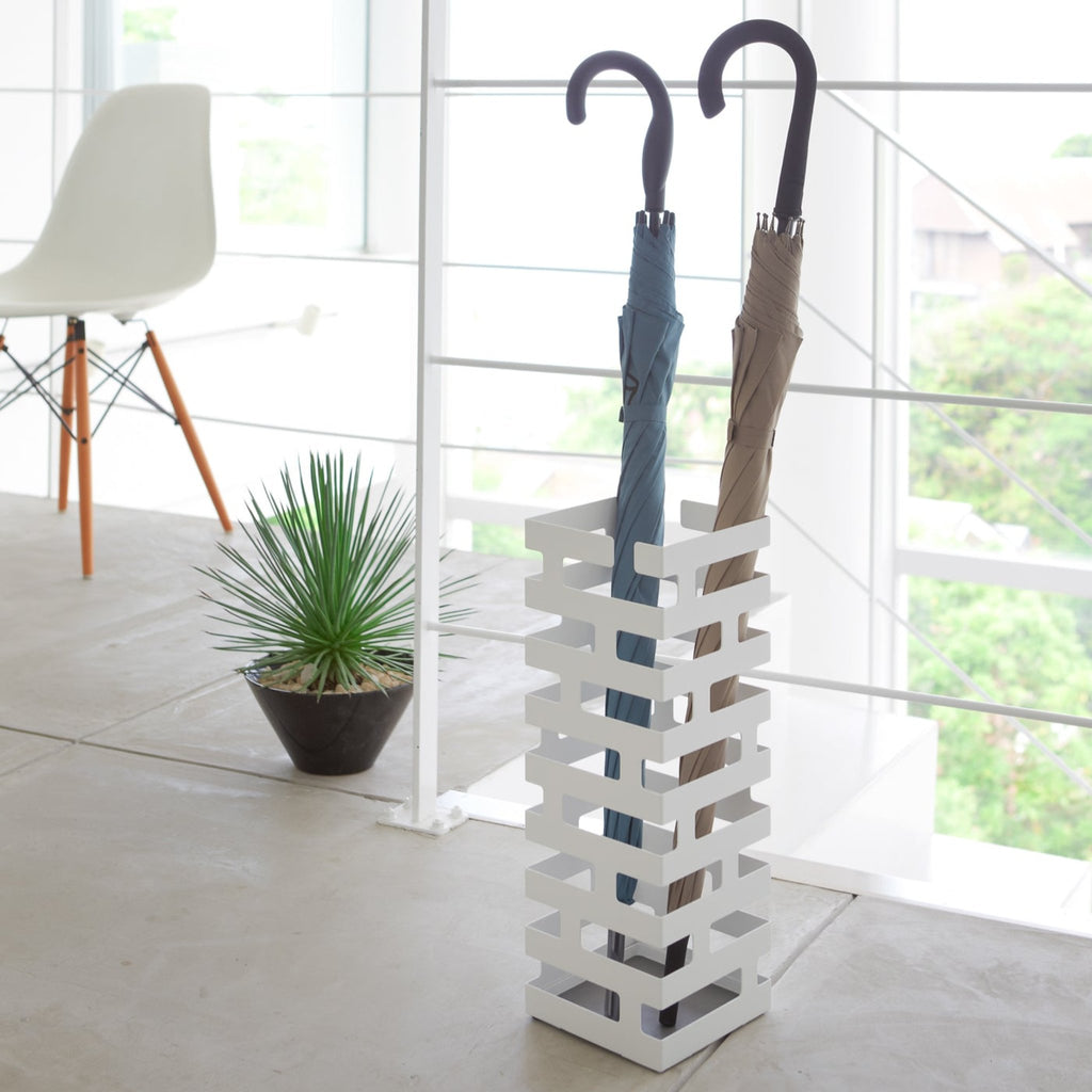 Yamazaki Home Brick Square White Umbrella Stand. SKU 2662. This brickwork-inspired umbrella stand offers both eye-catching design and functionality. Keep long umbrellas upright in the non-slip holder while looping hand umbrellas on top rungs.