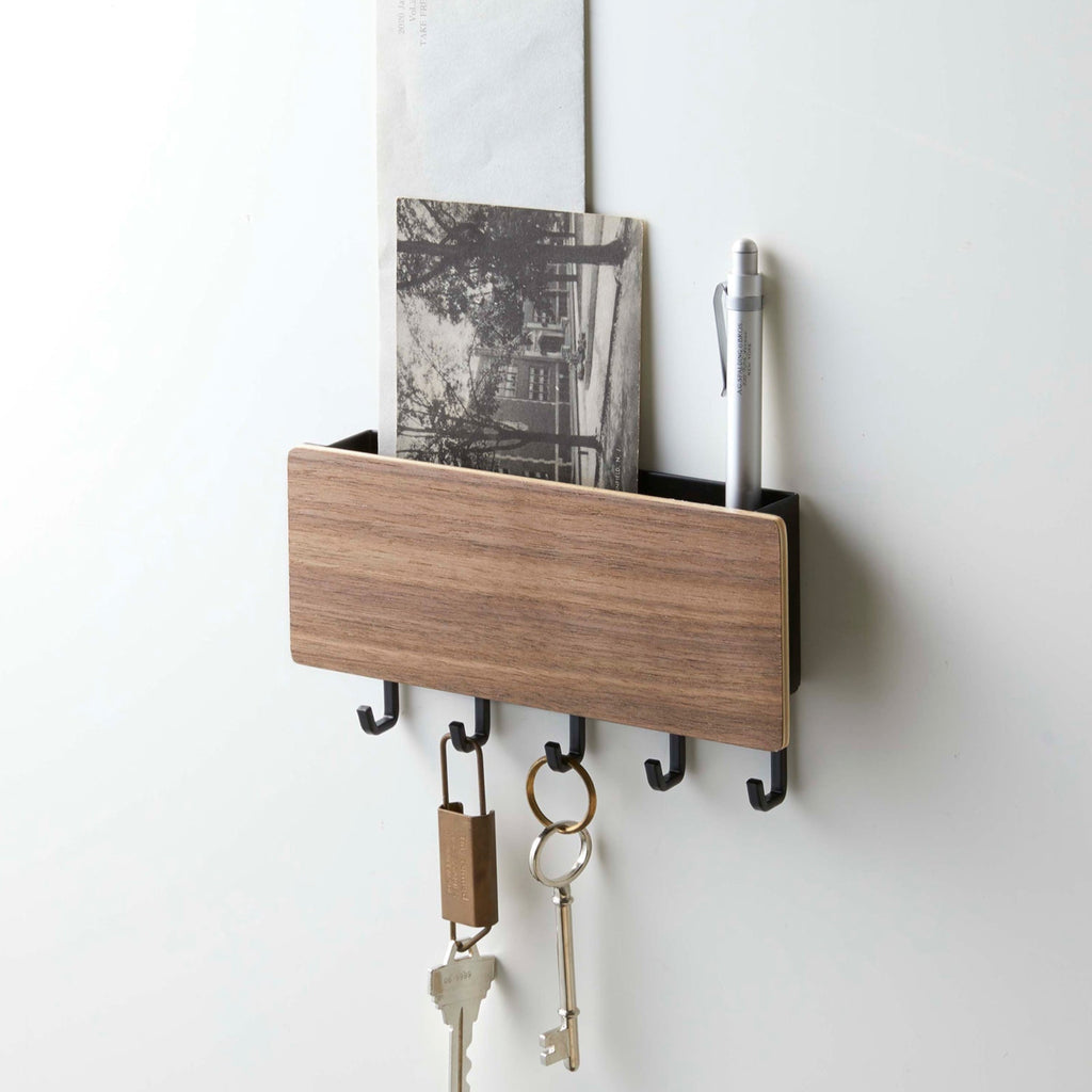 Time to upgrade from the catch-all bowl in your entryway! Five hooks for hanging keys, keychains, fobs, or masks across the bottom of this entryway organizer. Tuck mail, sunglasses, sunscreen, or anything else you don't want to forget as you leave home into the upper compartment.