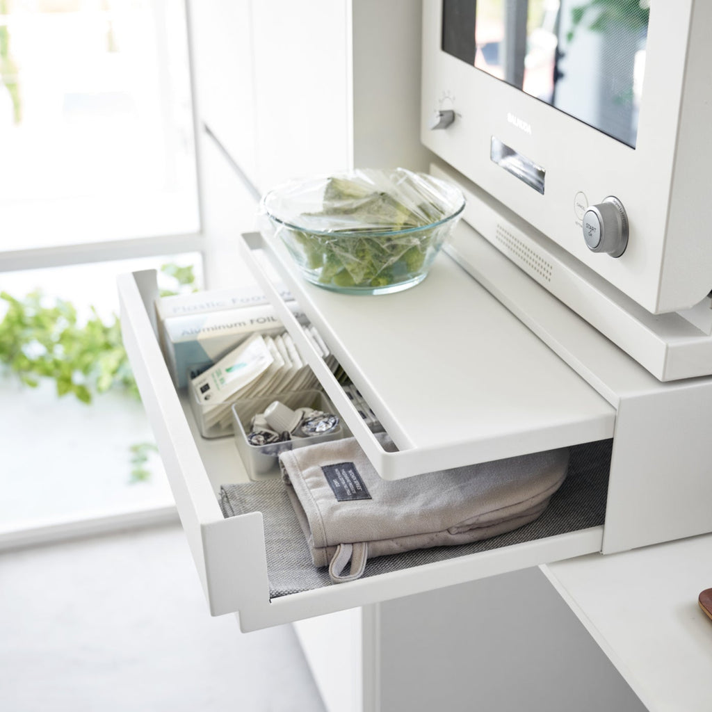 A kitchen drawer, pull-out shelf, and appliance stand in one, this organizer creates space and convenience in the kitchen.