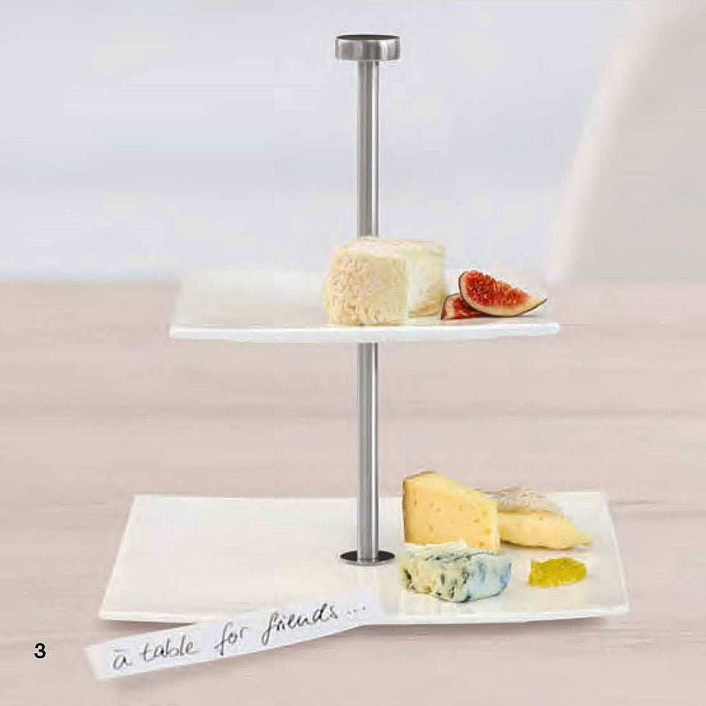 The etagere made of two white porcelain plates has a handle made of stainless steel (height: 23.5 cm), the plates shine beautifully. 