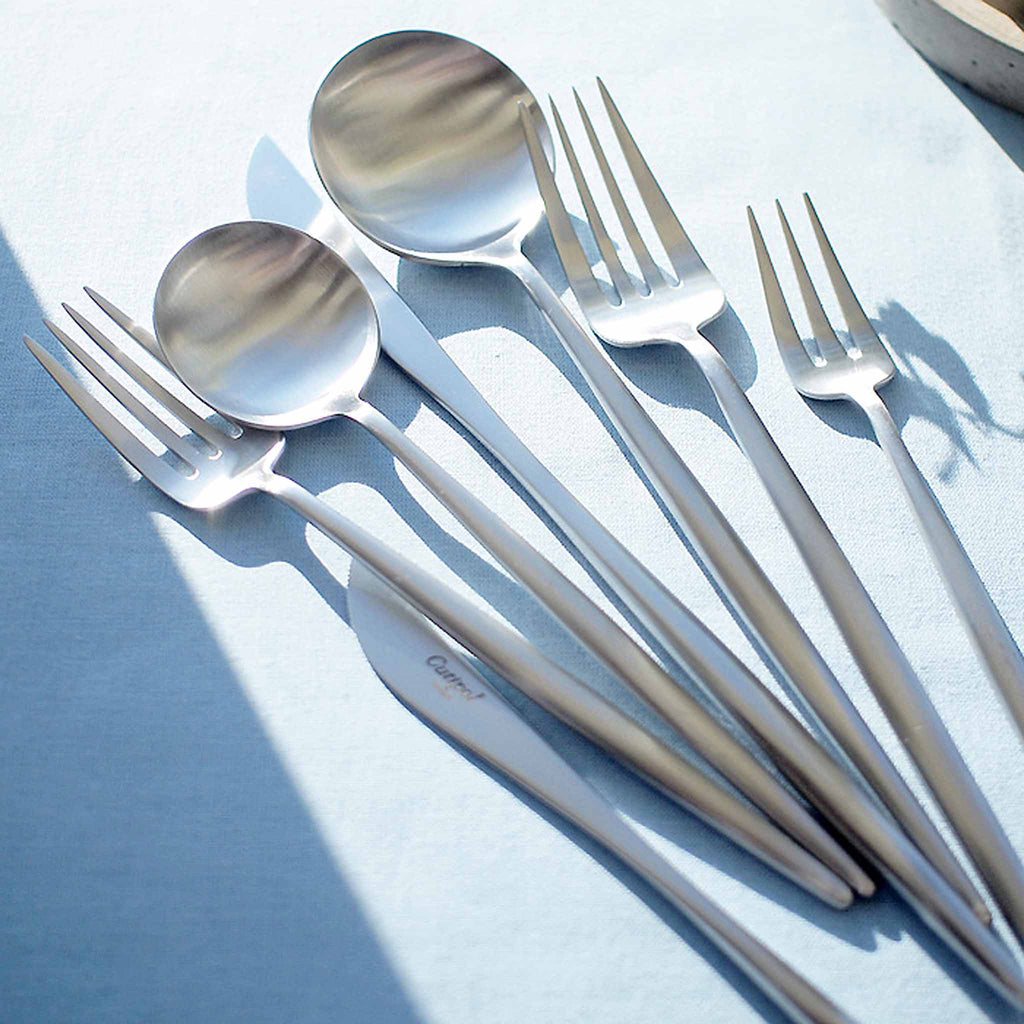 Cutipol Moon Polished Steel Cutlery Collection. Characterized by its graceful form, full of elegance, softness and lightness that communicate an empathetic and emotional strength. The round-shaped spoon evokes the moonlight nostalgia enhancing the poetic and symbolic.