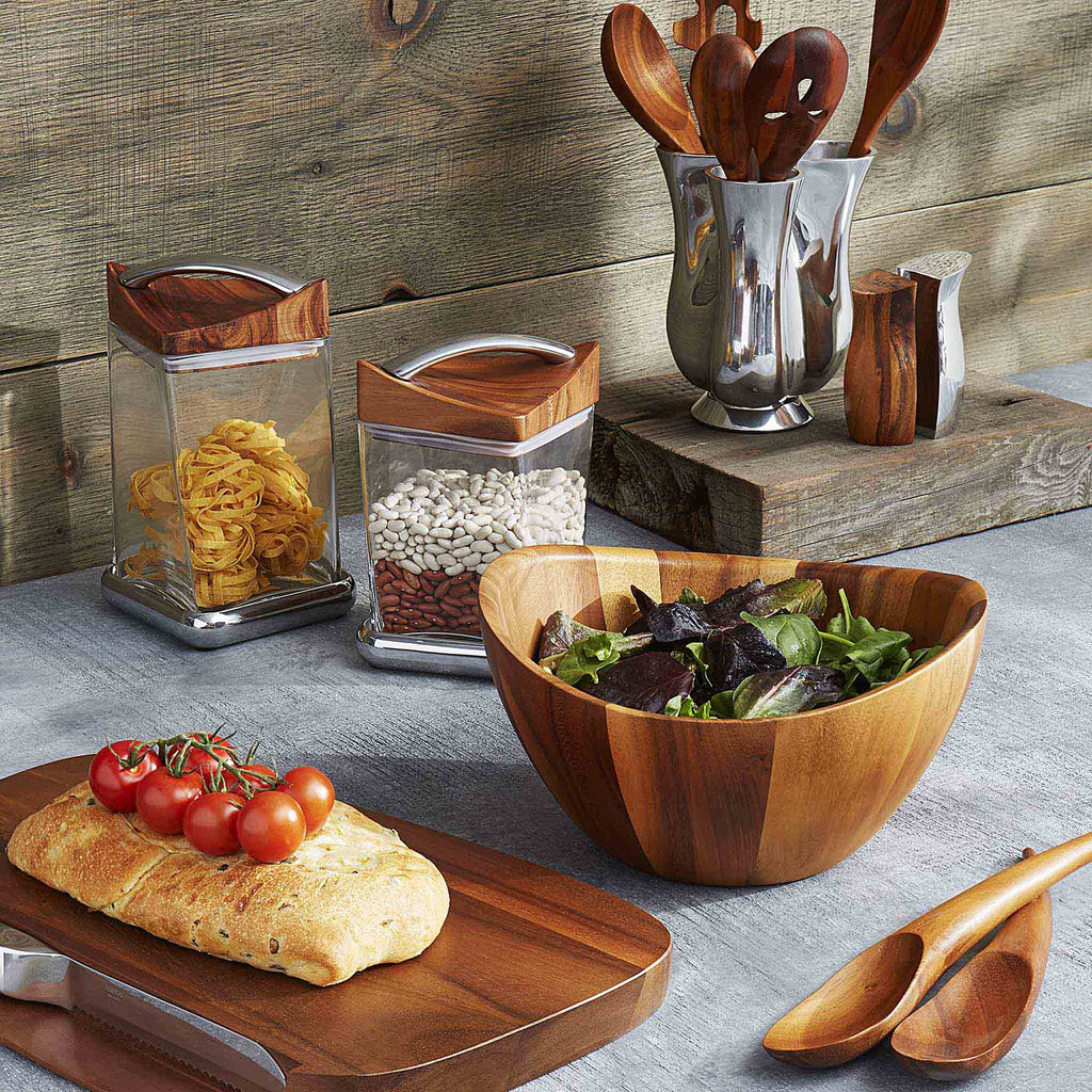 Elegant lines and flowing curves done in rich, gorgeous acacia wood make the Harmony Salad Set an instant classic. The generously rounded bowl paired with the unique shape of the tongs make it easy to toss and arrange your healthy creations. 