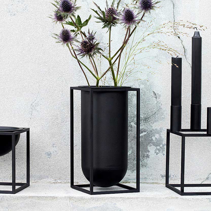 Kubus Vase Lily was designed by Søren Lassen in 2018 as the third in the series of vases in the Kubus collection. With its cylindrical container positioned in the rectangular base of the characteristic 6 mm thin square profiles, the vase draws on both feminine and masculine expressions. 