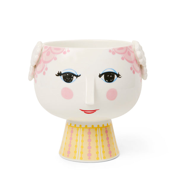 Bjørn Wiinblad Eva Flowerpot on Base Ø6.1 in/15.5 cm. Art. 56535. UPC 5709513565352. Bjørn Wiinblad represents everything that is crazy, quirky, creative and wonderful. And with the beautiful and smiling Eva flowerpot from Bjørn Wiinblad with pink hair and a bright pink and yellow dress, you can create a quirky, colorful vibe throughout your home. 